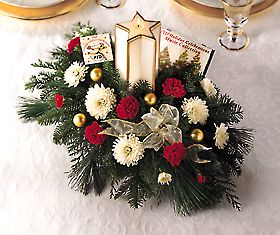 holiday arrangement with a  glowing  star-shaped candle, red 		and white flowers and Christmas greens