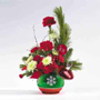  holiday floral arrangement is crafted of fine ceramic with a metallic finish. Filled with Christmas greens, red carnations, white mums and ribbon.
